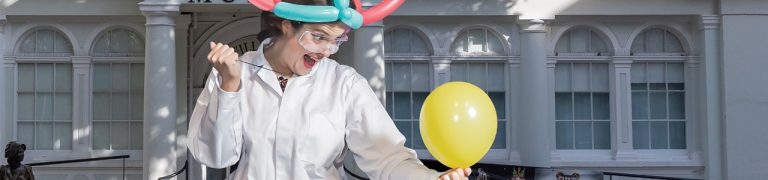 A banner image shows a person dressed in a white lab coat, they hold a balloon and have a menacing face as they look on to pop the balloon. In the background is the Willis Museum in Basingstoke town centre.