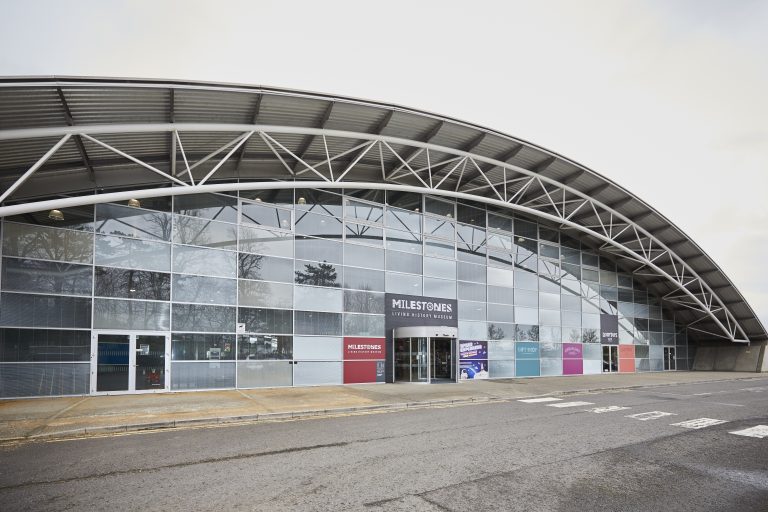 A glass and steel building with a curved roof.