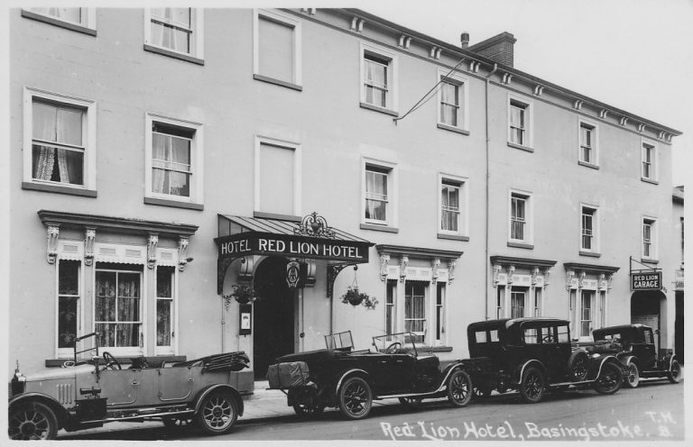 An old photograph of the Red Lion Hotel in Basingstoke. A black and white image of a three storey building on a street.